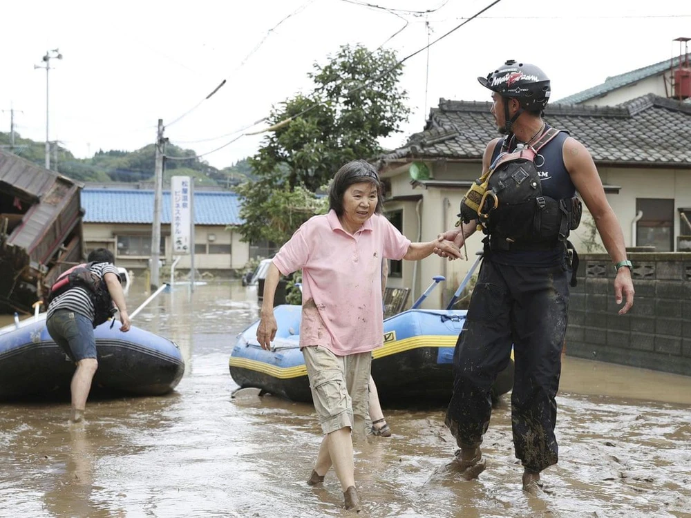Nhân viên cứu hộ hỗ trợ người dân sơ tán khỏi vùng ngập lụt tại tỉnh Kumamoto, Nhật Bản ngày 4/7/2020. (Ảnh: Kyodo/TTXVN)