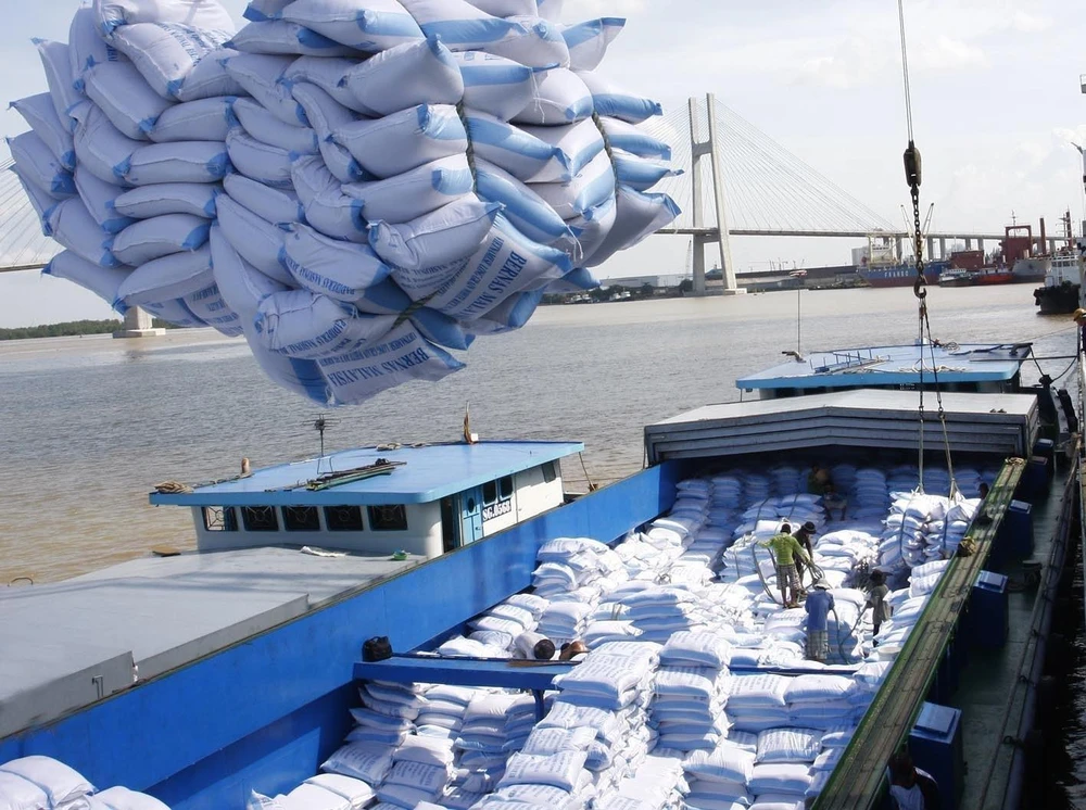 Bốc xếp gạo xuất khẩu sang tại cảng Sài Gòn. (Ảnh: TTXVN)