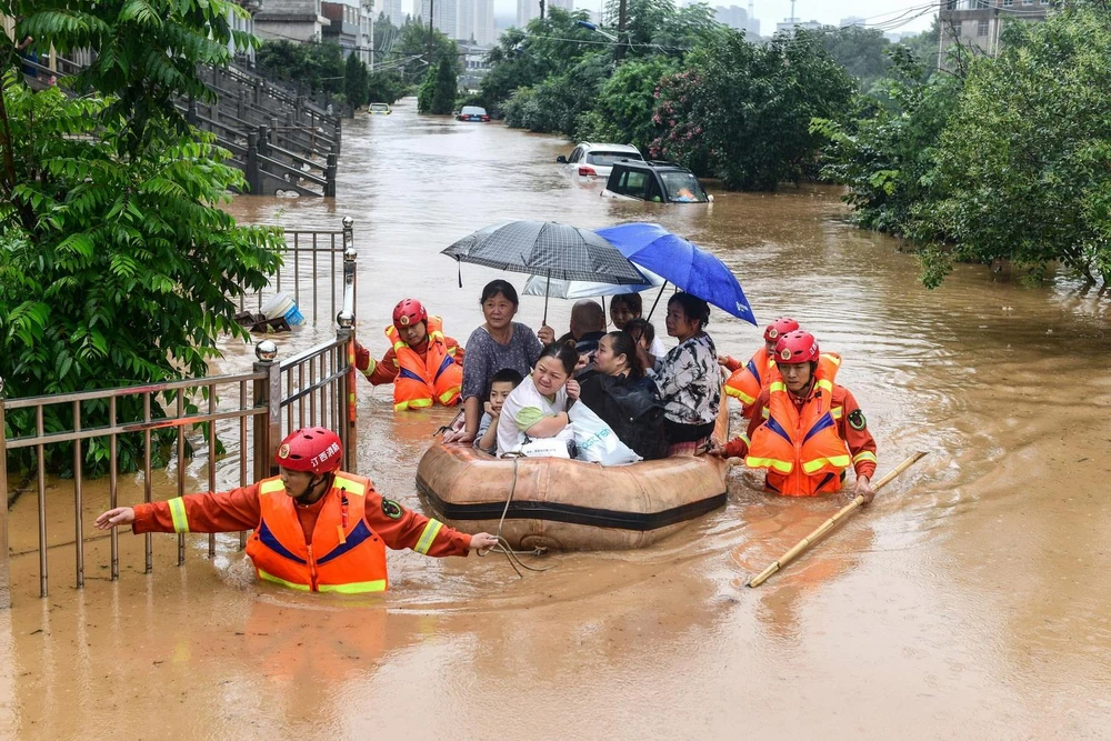 Sơ tán người dân khỏi các khu vực ngập lụt ở tỉnh Giang Tô, Trung Quốc, ngày 8/7/2020. (Ảnh: AFP/TTXVN)