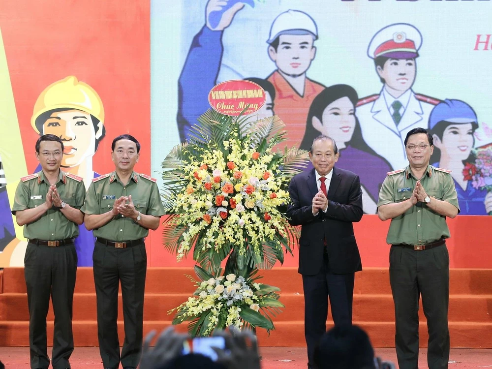 Phó Thủ tướng Thường trực Chính phủ Trương Hòa Bình tặng hoa chúc mừng Bộ Công an. (Ảnh: Doãn Tấn/TTXVN)