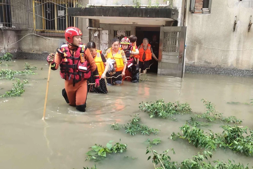 Lực lượng cứu hộ sơ tán người dân khỏi vùng ngập lụt tại tỉnh Tứ Xuyên, tây nam Trung Quốc, ngày 12/8/2020. (Ảnh: THX/TTXVN)