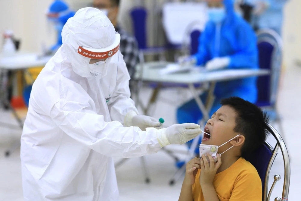 Nhân viên y tế Hà Nội tiến hành lấy mẫu dịch hầu họng để xét nghiệm bằng phương pháp RT-PCR của người dân từ Đà Nẵng trở về. (Ảnh: Thành Đạt/TTXVN)