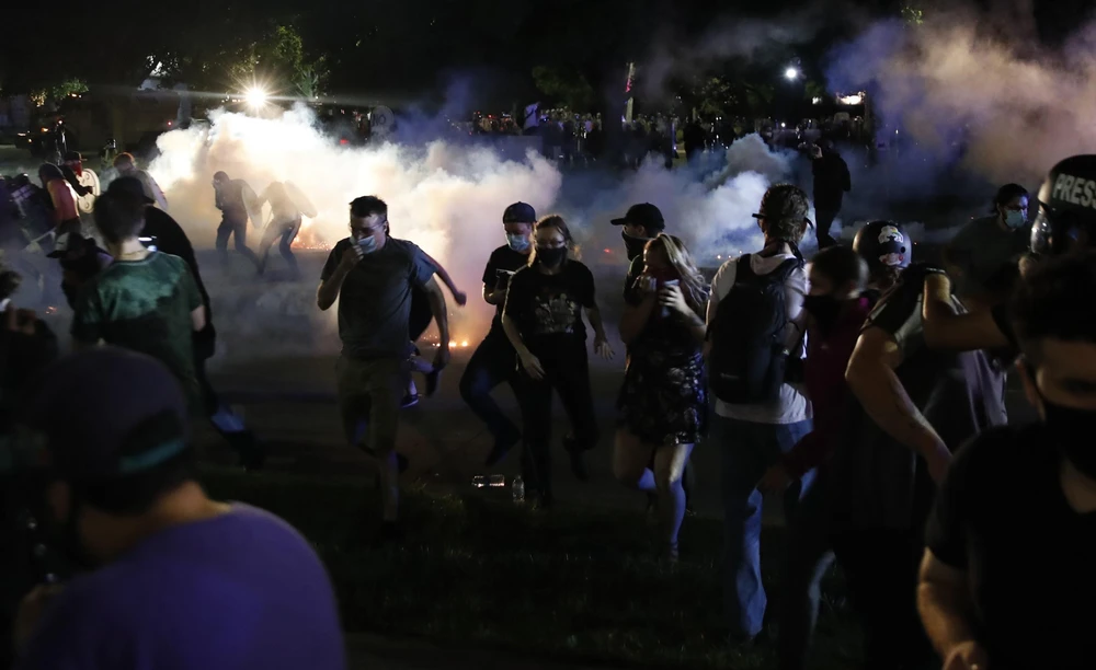 Người biểu tình xung đột với cảnh sát trong cuộc tuần hành phản đối vụ cảnh sát bắn người da màu tại Kenosha, bang Wisconsin (Mỹ) ngày 25/8/2020. (Ảnh: AFP/TTXVN)