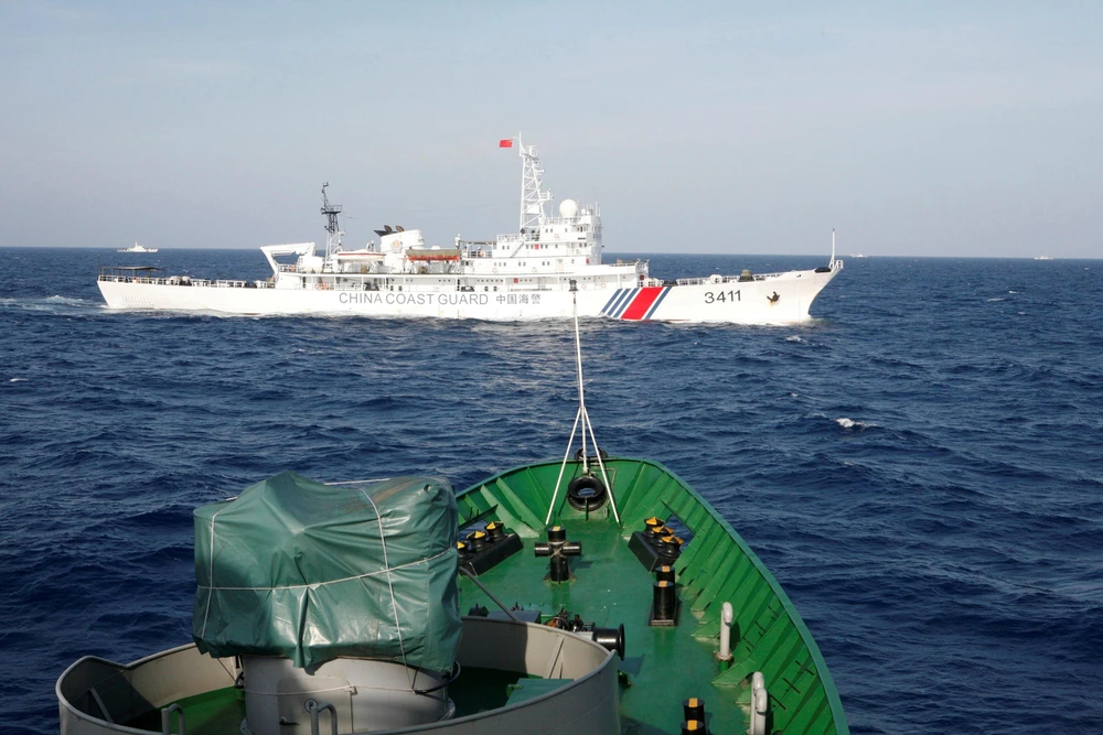 Tàu cảnh sát biển Việt Nam giám sát một tàu hải cảnh cảu Trung Quốc hoạt động trái phép tại Biển Đông. (Nguồn: Reuters)