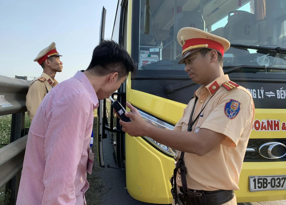 Cán bộ Phòng Cảnh sát giao thông Công an tỉnh Nam Định thực hiện kiểm tra nồng độ cồn trên quốc lộ 10. (Ảnh: Công Luật/TTXVN)