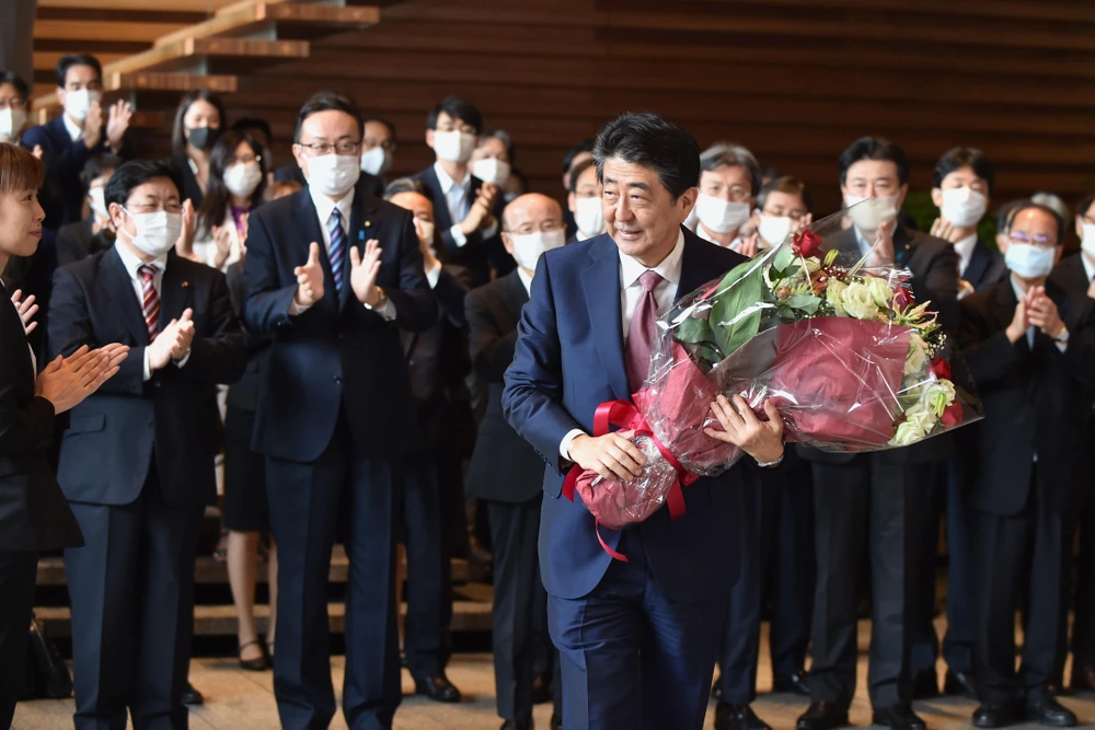 Cựu Thủ tướng Abe Shizo nhận hoa chúc mừng sau khi toàn bộ nội các do ông lãnh đạo từ chức, tại Tokyo ngày 16/9/2020. (Ảnh: AFP/TTXVN)