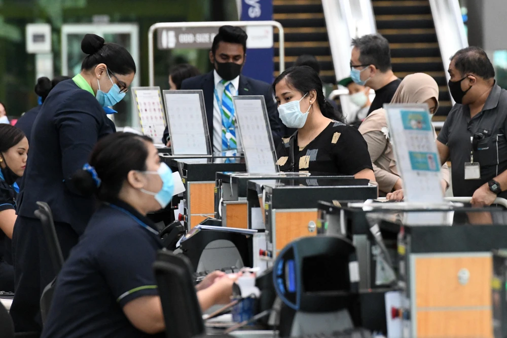 Hành khách làm thủ tục tại sân bay quốc tế Changi ở Singapore ngày 8/6/2020. (Ảnh: AFP/TTXVN)