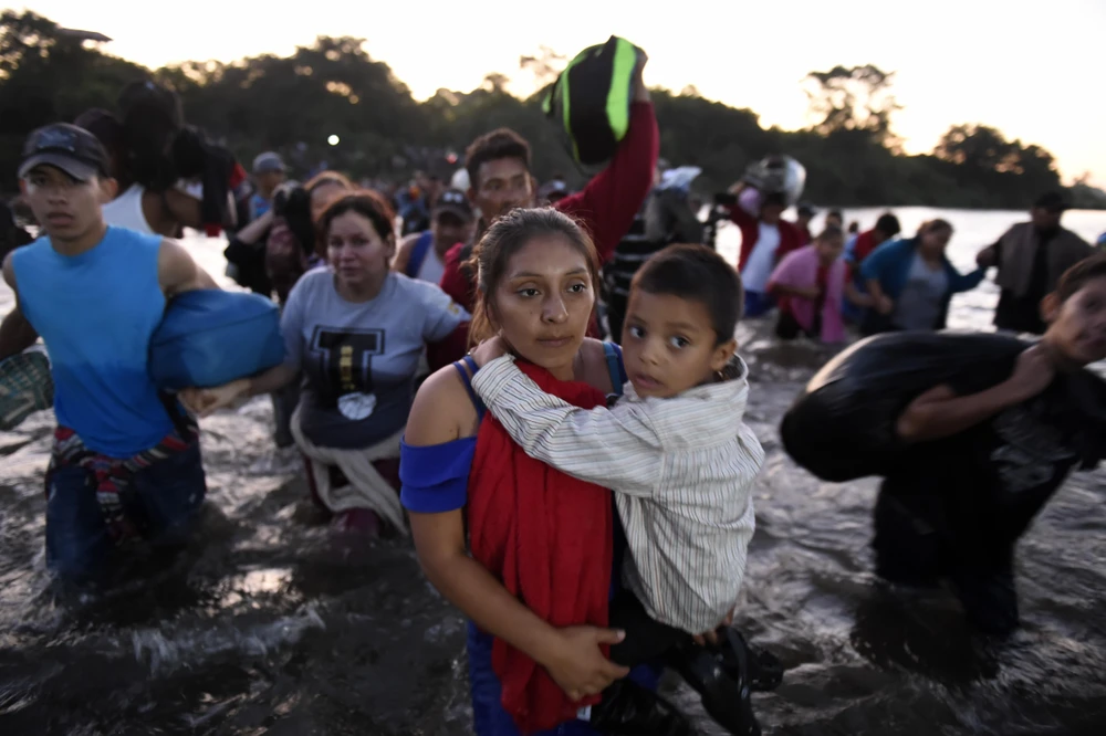 Người di cư vượt sông Suchiate từ Tecun Uman (Guatemala) trong hành trình tới Mỹ ngày 23/1/2020. (Ảnh: AFP/TTXVN)