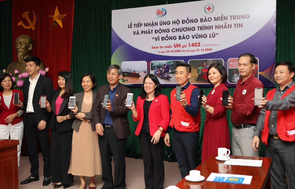 Lãnh đạo Hội Chữ thập đỏ Việt Nam và các đại biểu nhắn tin ủng hộ Vì đồng bào vùng lũ. (Ảnh: Thanh Tùng/TTXVN)