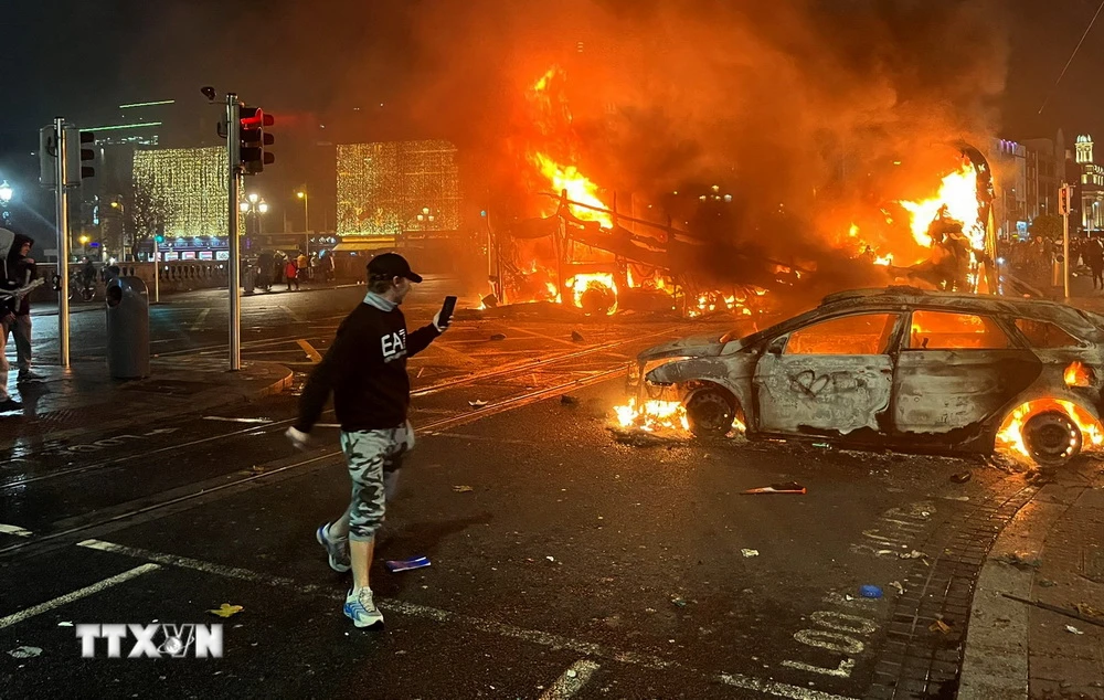 Người biểu tình đốt cháy các phương tiện trên đường phố tại Dublin, Ireland, sau vụ tấn công bằng dao ngày 23/11/2023. (Ảnh: AFP/TTXVN)