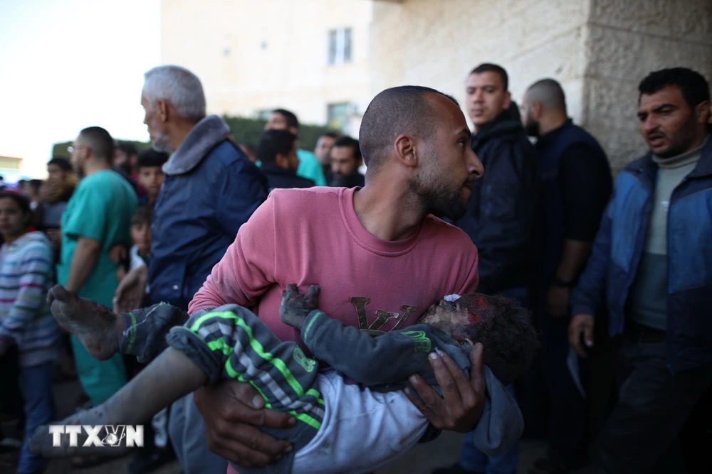 Chuyển một em nhỏ bị thương trong cuộc không kích của Israel vào bệnh viện ở thành phố Deir el-Balah, Dải Gaza, ngày 11/12/2023. (Ảnh: THX/TTXVN)