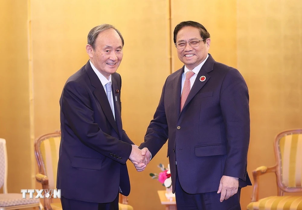 Thủ tướng Phạm Minh Chính gặp cựu Thủ tướng Nhật Bản Suga Yoshihide. (Ảnh: Dương Giang/TTXVN)