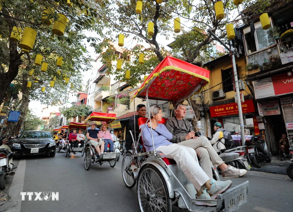 Du khách nước ngoài sử dụng xích lô dạo quanh phố phường, thưởng ngoạn nét đẹp cổ kính của Hà Nội. (Ảnh: Thanh Tùng/TTXVN)