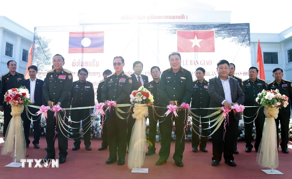 Đại diện Bộ Quốc phòng Việt Nam và Lào cắt băng khánh thành và bàn giao Công trình. (Ảnh: Phạm Kiên/TTXVN)