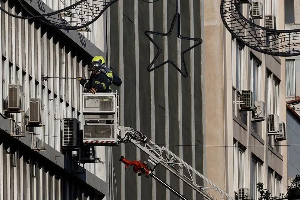 Lực lượng cứu hỏa thay những tấm kính vỡ sau vụ nổ tại Athens ngày 3/2/2024. (Ảnh: Reuters)