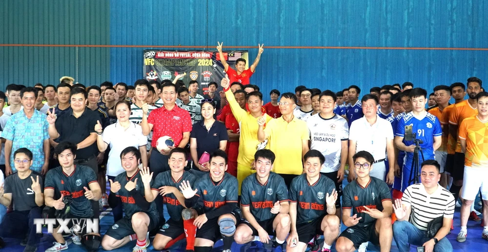 Đại sứ Việt Nam tại Malaysia Đinh Ngọc Linh (áo đỏ) chụp ảnh kỷ niệm cùng các cầu thủ tham dự giải bóng đá của cộng đồng người Việt tại Malaysia. (Ảnh: Hằng Linh/TTXVN)