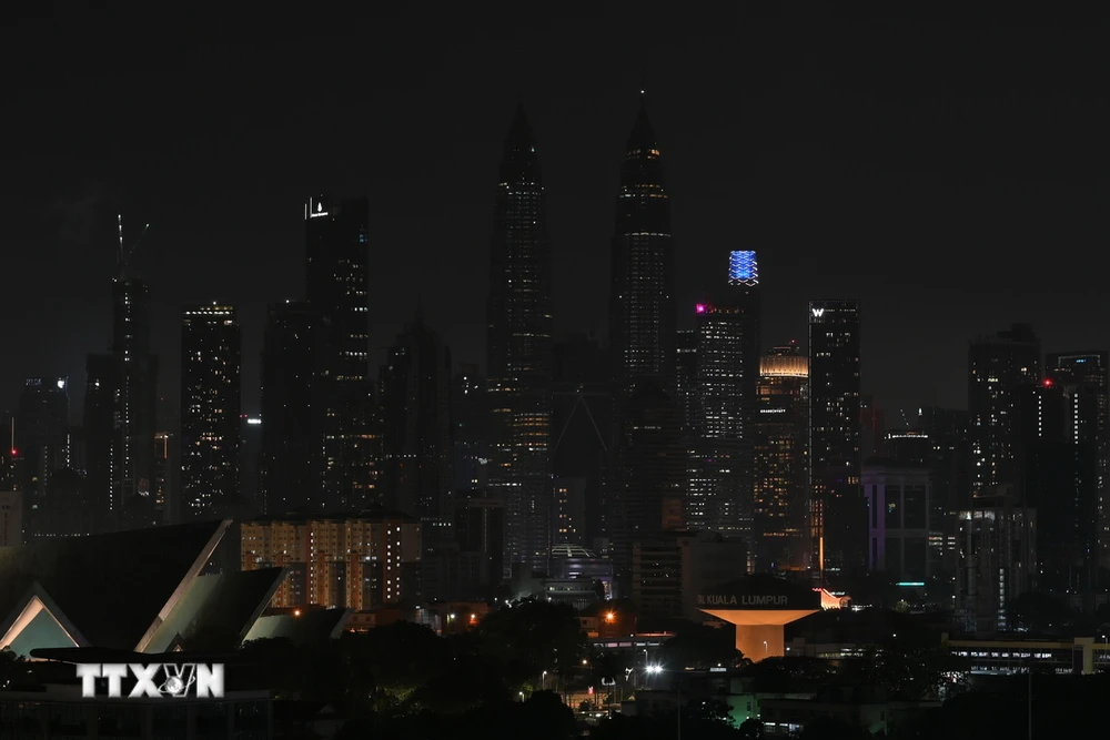 Tắt đèn hưởng ứng chiến dịch Giờ Trái Đất tại toà tháp đôi Petronas ở Kuala Lumpur, Malaysia, ngày 25/3/2023. (Ảnh: THX/TTXVN)