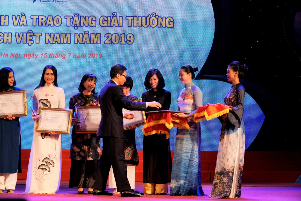 Phó Thủ tướng Chính phủ Vũ Đức Đam, Trưởng Ban Chỉ đạo Nhà nước về Du lịch trao giải cho 5 "Đơn vị truyền thông có nhiều đóng góp cho ngành Du lịch Việt Nam năm 2019.” (Ảnh: Hoàng Hiếu/Vietnam+)