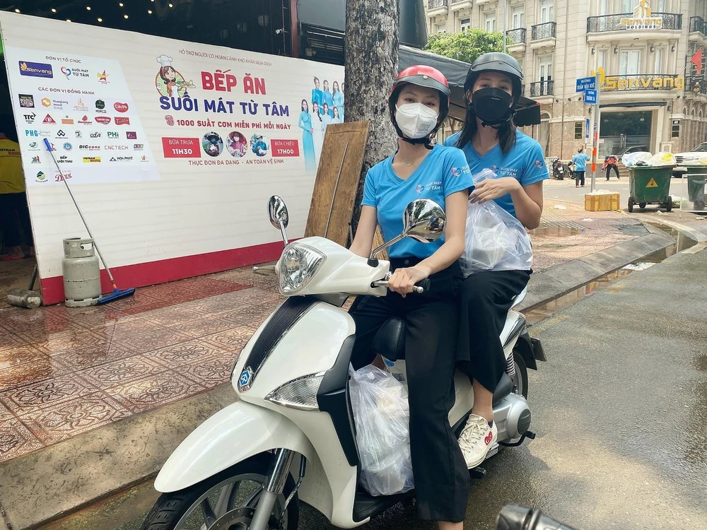 Hoa hậu Tiểu Vy và Á hậu Ngọc Thảo làm 'shipper' đi trao các suất ăn cho lực lượng đầu chống dịch. (Ảnh: CTV/Vietnam+)