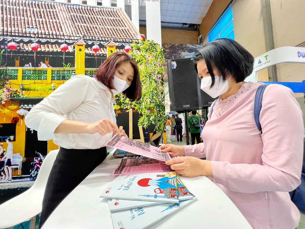 Lữ hành giới thiệu thông tin du lịch với khách tham quan tại Hội chợ Du lịch quốc tế 2022 vừa diễn ra tại Hà Nội. (Ảnh minh họa: Mai Mai/Vietnam+)