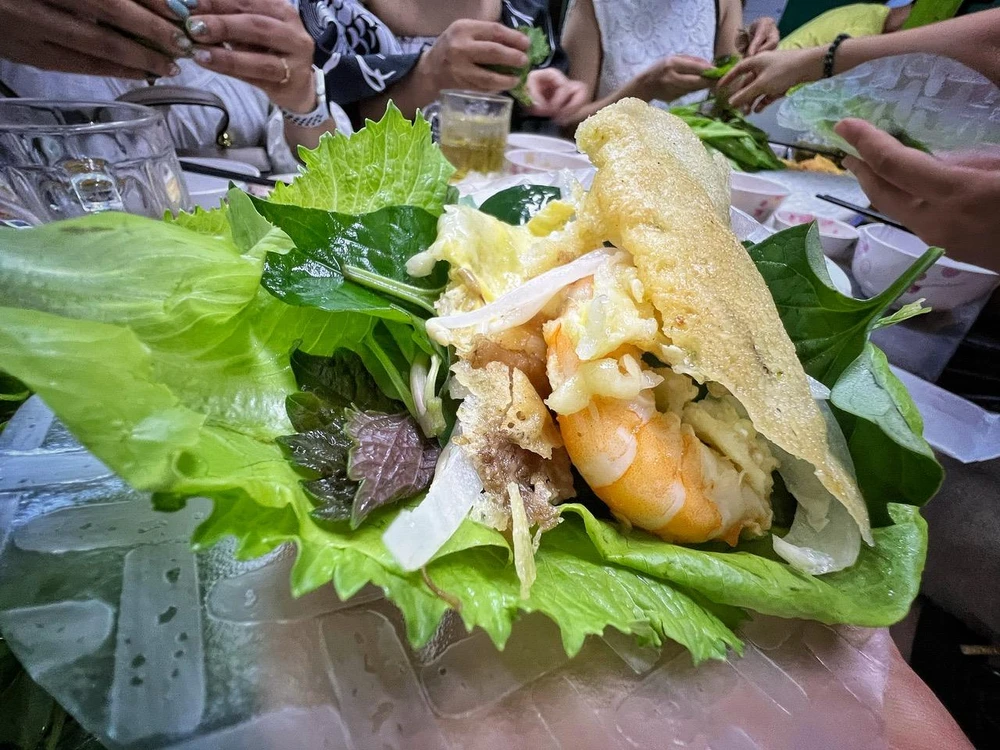 Du khách thưởng thức bánh xèo, món ngon Sài thành. (Ảnh: Mai Mai/Vietnam+)