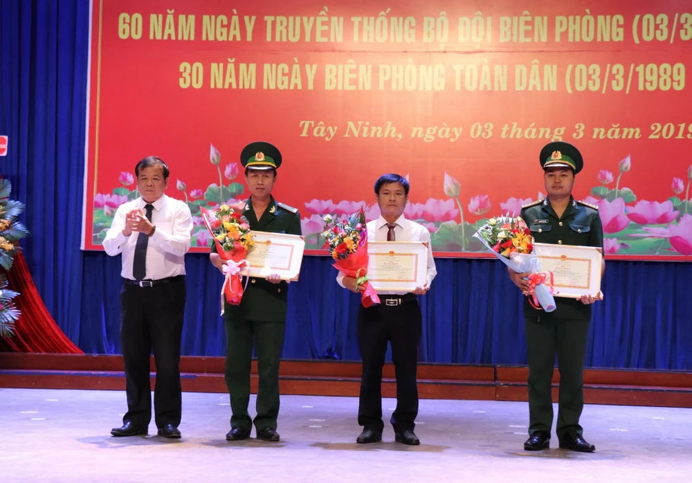 Chủ tịch UBND tỉnh Tây Ninh Phạm Văn Tân tặng bằng khen của Bộ trưởng Bộ Quốc phòng cho 1 tập thể và 2 cá nhân có thành tích đóng góp cho Bộ đội biên phòng. (Ảnh: Lê Đức Hoảnh/TTXVN)