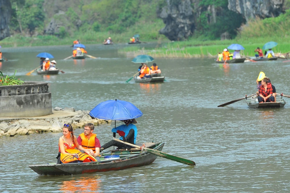 Du khách trong và ngoài nước tham quan khu du lịch Tam Cốc (Ninh Bình) bằng thuyền. (Ảnh: Minh Đức/TTXVN)