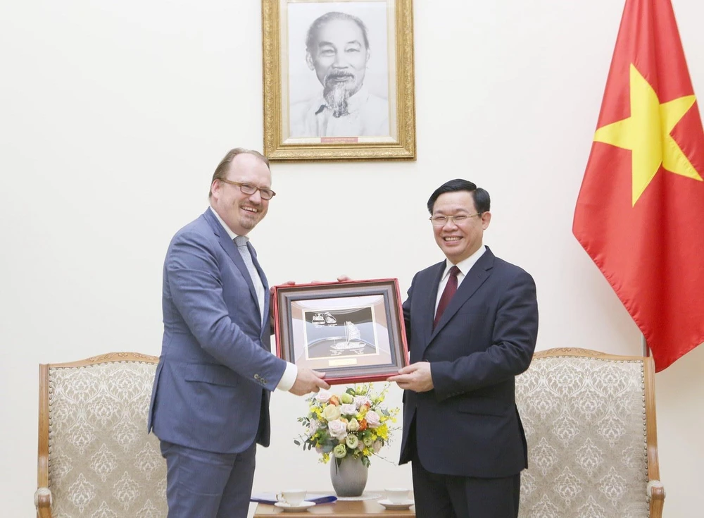 Phó Thủ tướng Vương Đình Huệ tặng quà lưu niệm cho ông Andrea Schaal. (Ảnh: Dương Giang/TTXVN)