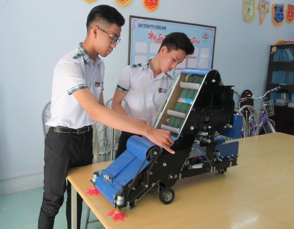 Nguyễn Hữu Thực và Trần Hoàng Nguyên với mô hình máy điều khiển tự động thu gom nông sản. (Ảnh: Nguyễn Thành/TTXVN)