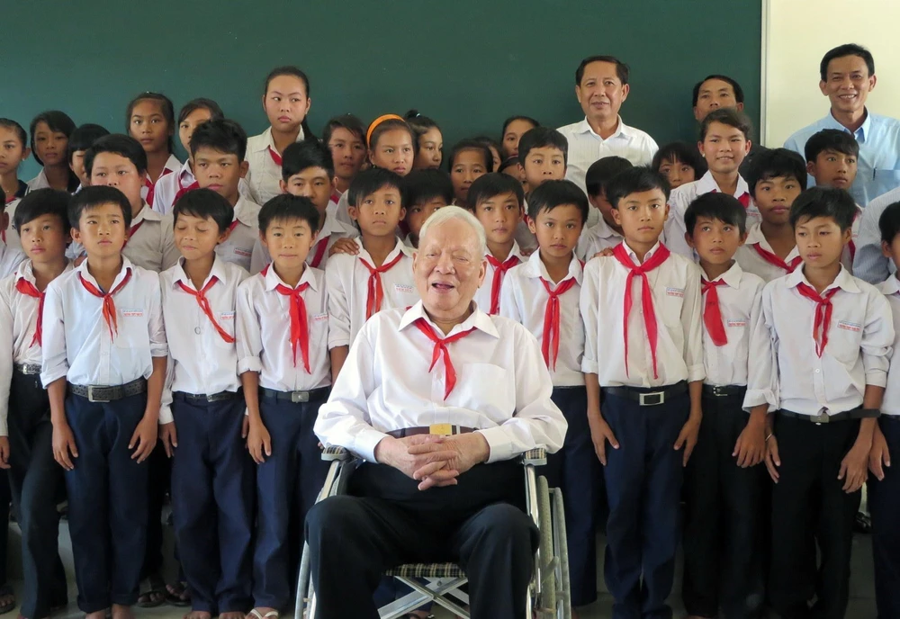 Đại tướng Lê Đức Anh chụp ảnh lưu niệm với các em học sinh Trường THPT Nam Yên, huyện An Biên, tỉnh Kiên Giang. (Ảnh: TTXVN)
