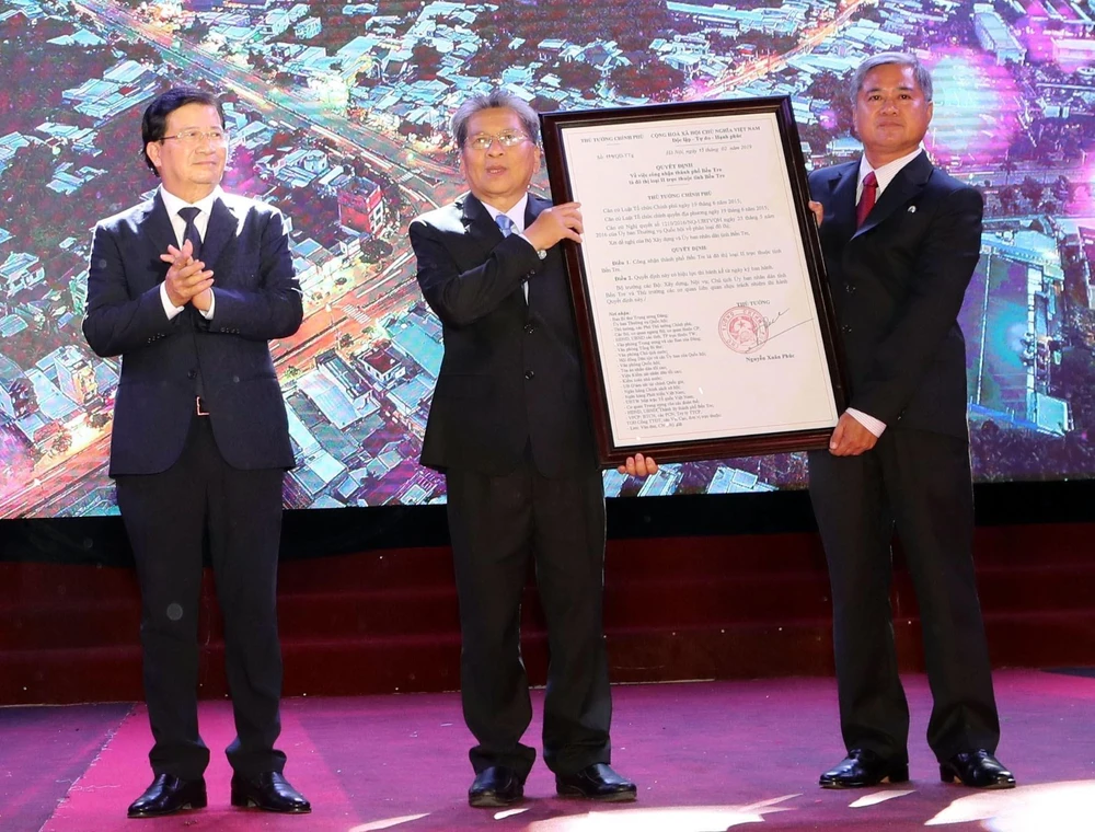 Phó Thủ tướng Trịnh Đình Dũng trao Quyết định của Thủ tướng Chính phủ công nhận thành phố Bến Tre là đô thị loại II trực thuộc tỉnh Bến Tre. (Ảnh: Trọng Đức/TTXVN)