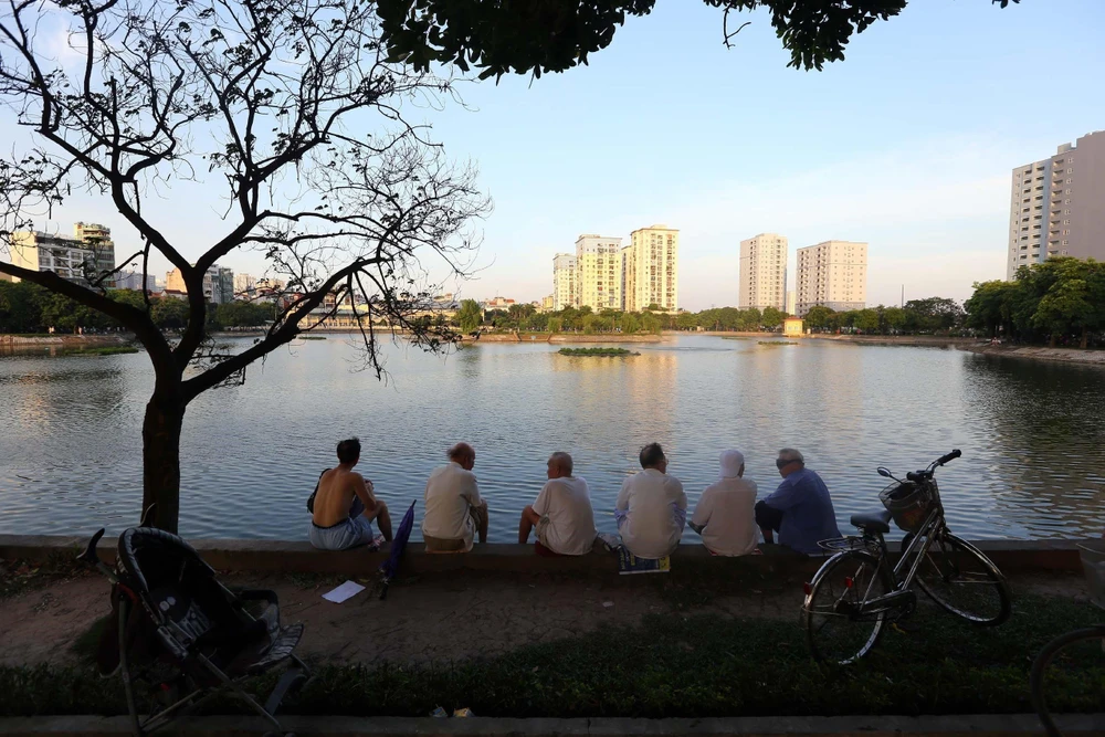 Người dân thủ đô đến các công viên, bờ hồ... hóng mát sau một ngày nắng nóng gay gắt trên 40 độ C. (Ảnh: Danh Lam/TTXVN)