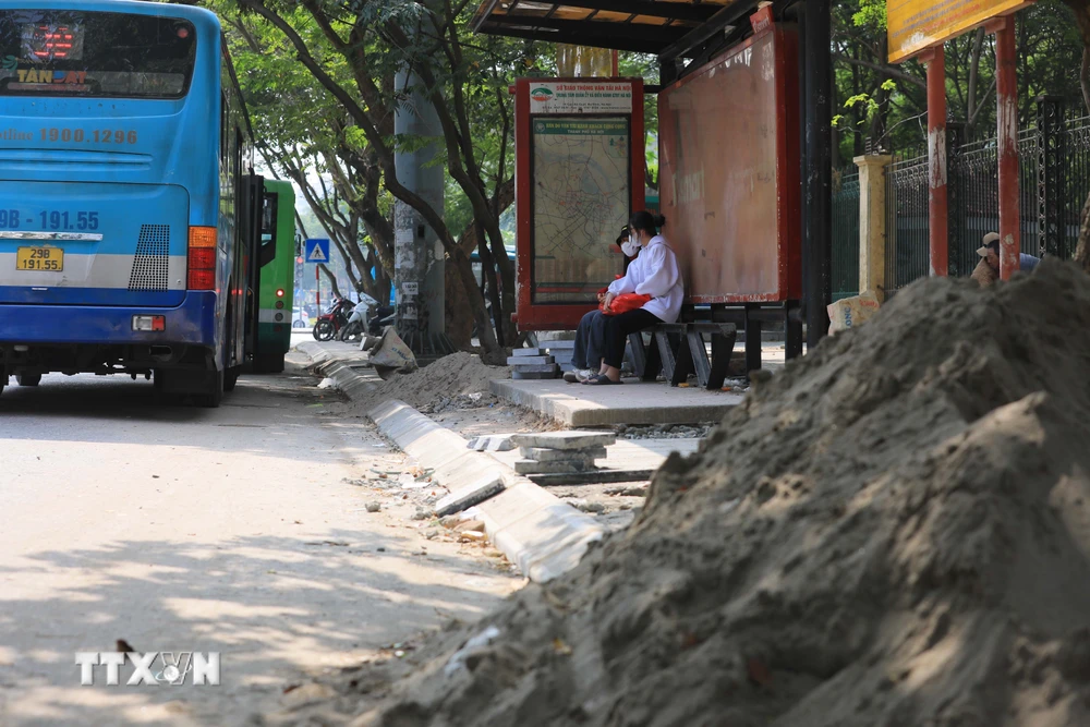 Cát, vật liệu xây dựng vỉa hè tràn ra đường Nguyễn Văn Huyên, quận Cầu Giấy gây mất an toàn giao thông. (Ảnh: Hoàng Hiếu/TTXVN)