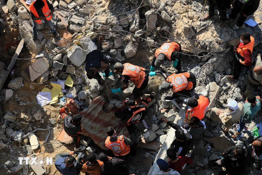 Lực lượng cứu hộ tìm kiếm các nạn nhân sau vụ oanh tạc của Israel xuống thành phố Rafah, phía Nam Dải Gaza ngày 19/12. (Ảnh: THX/TTXVN)