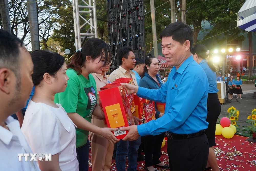 Ông Phạm Chí Tâm, Phó Chủ tịch Liên đoàn Lao động Thành phố Hồ Chí Minh tăng quà cho công nhân lao động. (Ảnh: Thanh Vũ/TTXVN)