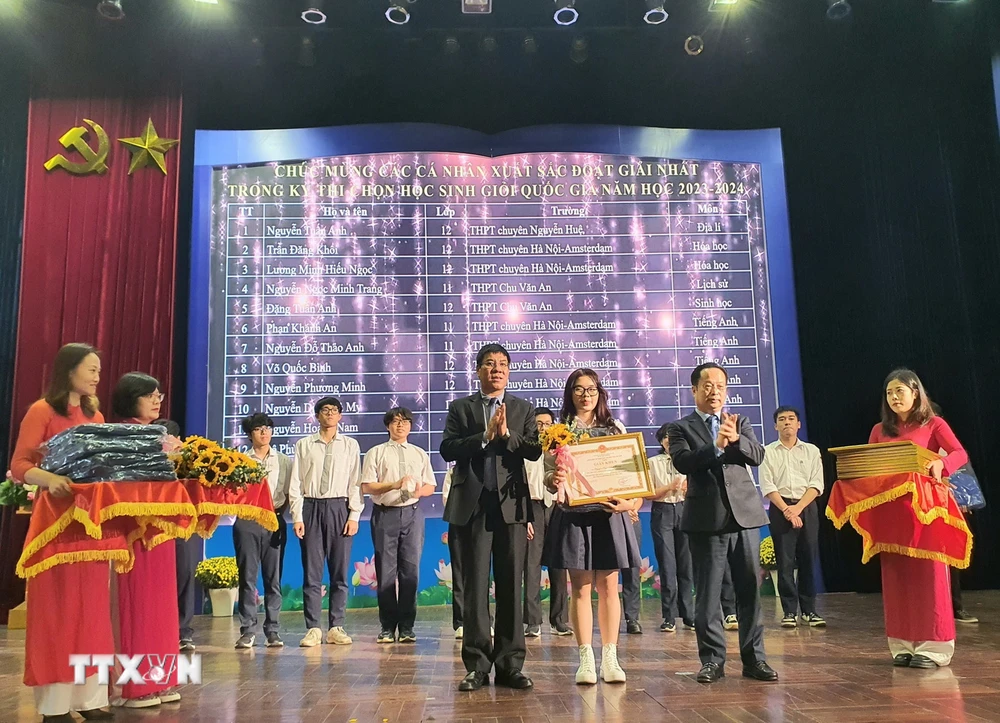 Trao giấy khen cho học sinh giành giải Nhất. (Ảnh: Nguyễn Cúc/TTXVN)