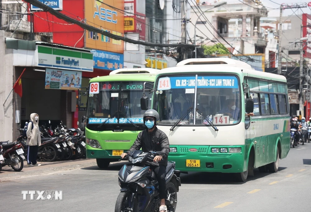 Người dân bịt kín khi lưu thông bằng xe máy trên đường ở Thành phố Hồ Chí Minh. (Ảnh: Hồng Đạt/TTXVN)