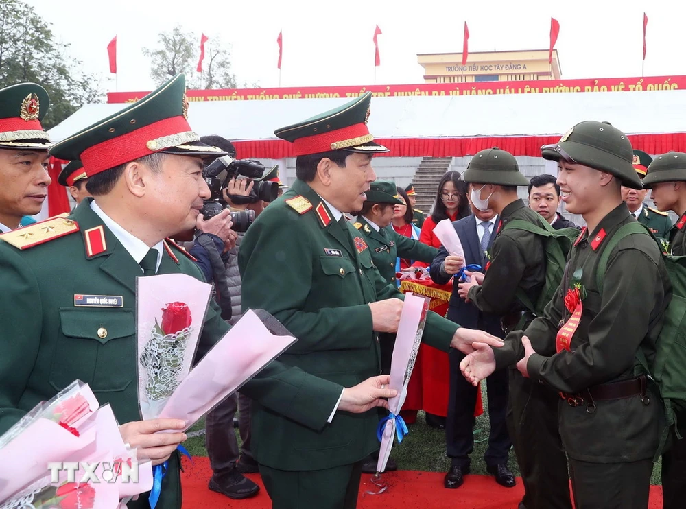 Đại tướng Lương Cường, Ủy viên Bộ Chính trị, Chủ nhiệm Tổng cục Chính trị Quân đội Nhân dân Việt Nam chúc mừng các thanh niên huyện Ba Vì lên đường nhập ngũ. (Ảnh: Trọng Đức/TTXVN)