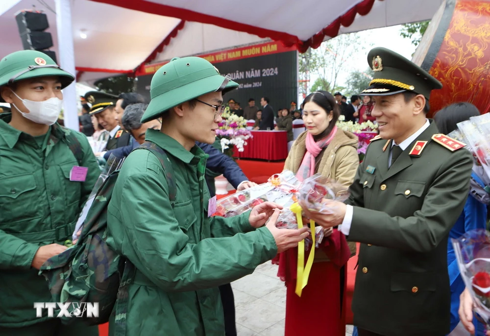Thượng tướng Lương Tam Quang, Ủy viên Trung ương Đảng, Thứ trưởng Bộ Công an tặng hoa chúc mừng các tân binh. (Ảnh: Thế Duyệt/TTXVN)