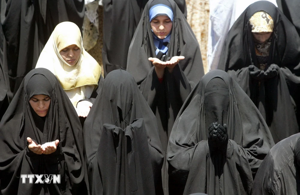 Phụ nữ Hồi giáo mặc áo choàng abaya tại một lễ cầu nguyện. (Ảnh: AFP/TTXVN)