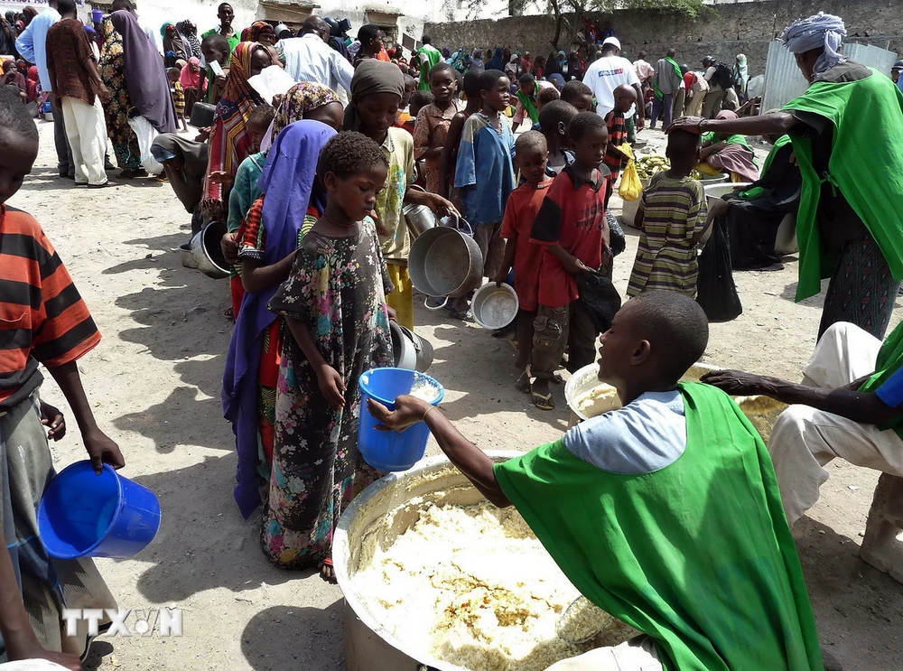 Trẻ em nhận lương thực cứu trợ tại Mogadishu, Somalia. (Ảnh: AFP/TTXVN)