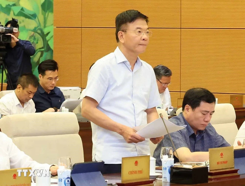 Bộ trưởng Bộ Tư pháp Lê Thành Long trình bày tờ trình. (Ảnh: Nhan Sáng/TTXVN)
