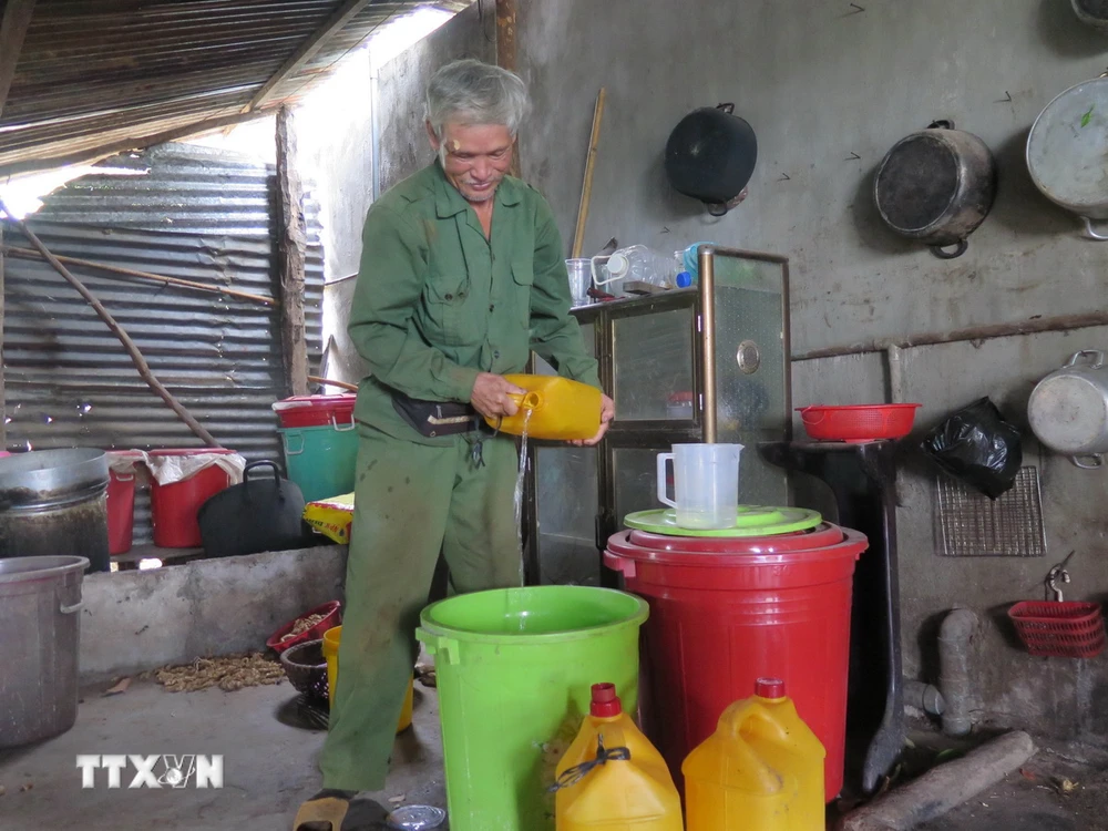 Ông Huỳnh Xuân Ba (thôn 2, xã Hòa Bình, thành phố Kon Tum) phải đi xin nước từ các hộ còn nước để tích lũy sử dụng. (Ảnh: Dư Toán/TTXVN)