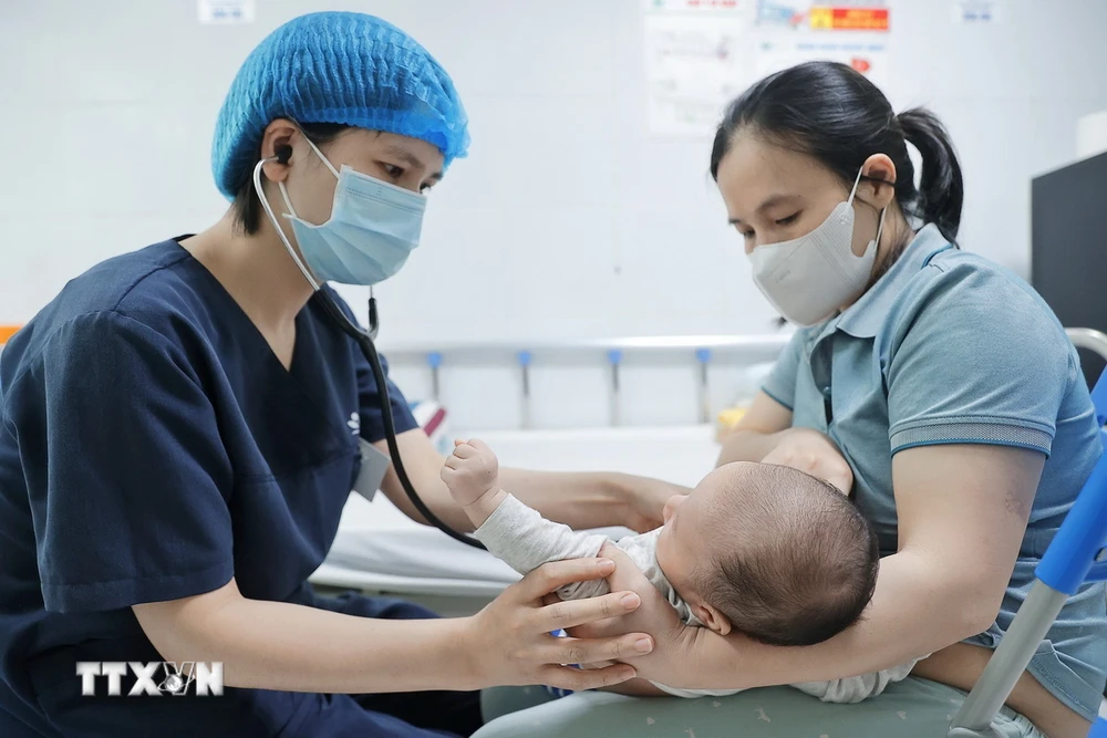 Bác sỹ khám cho bệnh nhi gần 2 tháng tuổi mắc ho gà đang điều trị tại Trung tâm bệnh Nhiệt đới (Bệnh viện Nhi Trung ương). (Ảnh: Minh Quyết/TTXVN)