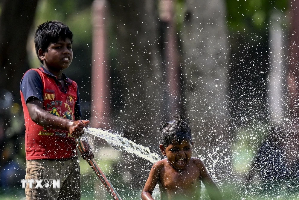 Trẻ em chơi đùa với nước trong ngày nắng nóng tại New Delhi, Ấn Độ, ngày 31/5. (Ảnh: AFP/TTXVN)