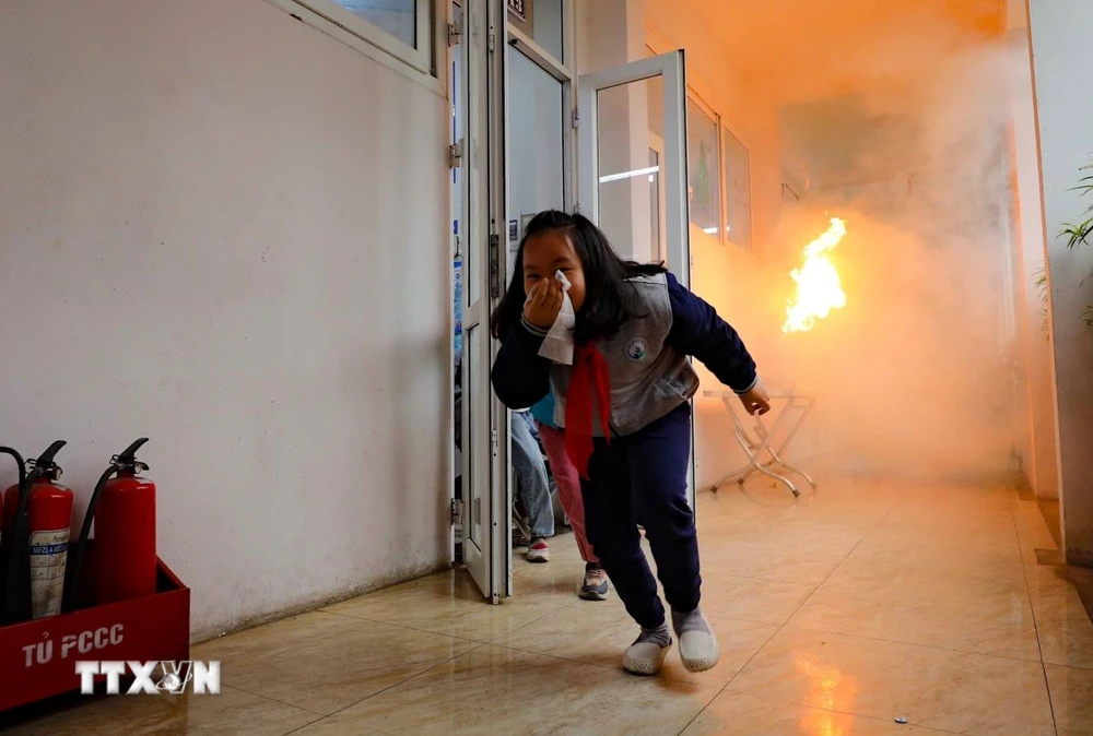 Học sinh tiểu học diễn tập thoát hiểm khi có đám cháy. (Ảnh: Thanh Tùng/TTXVN)