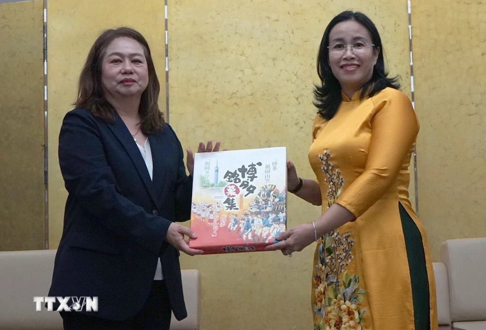 Phó Chủ tịch Ủy ban Nhân dân thành phố Đà Nẵng Nguyễn Thị Anh Thi (phải) nhận quà lưu niệm của bà Satomi Iwashige, Phó Hiệu trưởng Trường Đại học tỉnh Nagasaki. (Ảnh: Quốc Dũng/TTXVN)