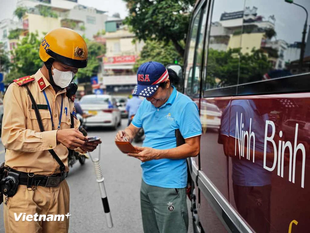 Cảnh sát giao thông tuần tra, xử lý xe khách, xe hợp đồng vi phạm trong khu vực phố cổ. (Ảnh Mạnh Khánh/Vietnam+)