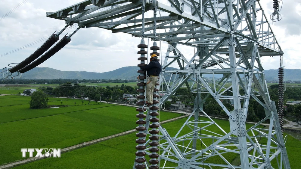 Nhà thầu thi công đường dây 500kV mạch 3 cố gắng lắp sứ và đưa dây lên cột đúng kế hoạch đề ra. (Ảnh: Việt Hoàng/TTXVN)