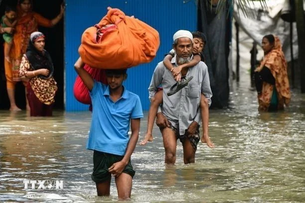 Người dân sơ tán khỏi vùng ngập lụt tại Feni, Chittagong, Bangladesh, ngày 23/8. (Ảnh: Getty Images/TTXVN)